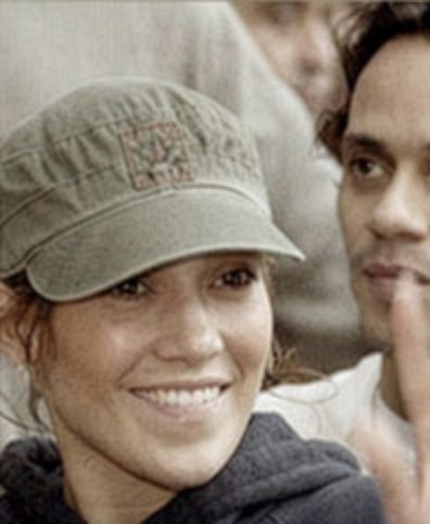 Jennifer Lopez w oliwkowozielonej czapce kadetce A. Kurtz z małym haftowanym logo, stojąca obok Marca Anthony'ego.
